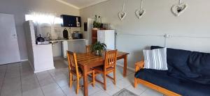 a kitchen and a living room with a table and a couch at Winemaker's Rest in Oudtshoorn +14 photos