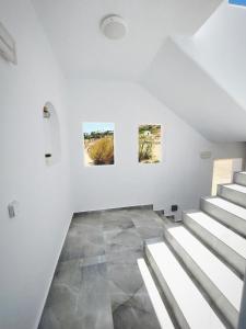 a white room with stairs and paintings on the wall at Cledari Plaka Appartments in Plaka