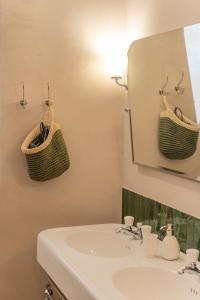 ein Badezimmer mit Waschbecken und Spiegel in der Unterkunft Domus Dionisio Apt by Addler House Ospitality in Syrakus + 27 Fotos