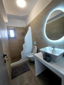a bathroom with a sink and a toilet and a mirror at Cledari Plaka Appartments in Plaka +39 photos