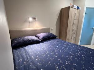 a bedroom with a blue bed with two pillows at Maramaa Backyard Bliss in Viljandi