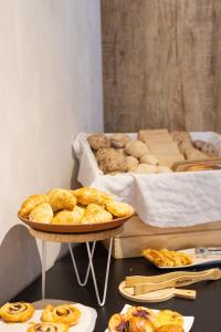 a table with two plates of pastries and a tray of bread at Hotel Farol in Praia da Barra +37 photos