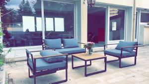 un patio con 2 sedie, un tavolo e un divano di La Vivaraize a Saint-Étienne