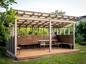 a wooden pergola with a table and benches at Maramaa Backyard Bliss in Viljandi