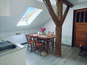 a kitchen with a table with chairs and a skylight at Stary Dom in Kandyty