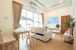 ein Wohnzimmer mit Tisch und Stühlen und ein Esszimmer in der Unterkunft Teddy House Cozy 3BD Poolvilla near Jomtien beach in Ban Huai Yai