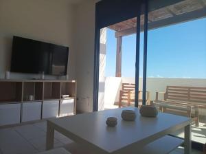 a living room with a table and a tv at Apartamento Califato 5 in Mojácar