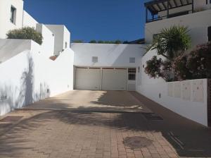 a white house with a driveway and a garage at Apartamento Califato 5 in Mojácar