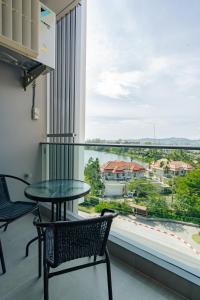 a balcony with a table and chairs and a large window at Laguna Lakeside apartments with panoramic view in Bang Tao Beach