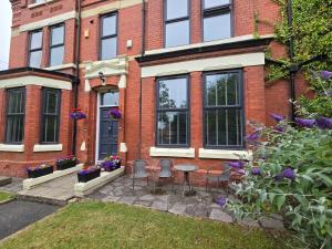 a brick house with a table and chairs in the yard at Victorian Renovation Room 7 in Liverpool