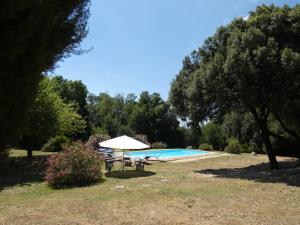 a swimming pool with an umbrella and a table and chairs at SCAPPO IN UMBRIA, Casale Monti in Montoro
