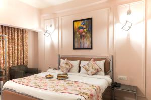 a bedroom with a bed and a painting on the wall at Ved A Boutique Stay in Jaipur +10 photos