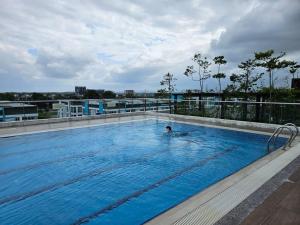 a person in a swimming pool on top of a building at TT3 soho kuching in Kuching +4 photos