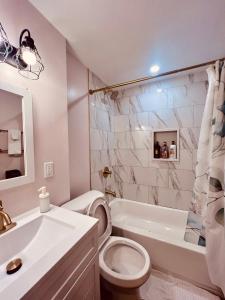 Un baño blanco con inodoro y lavabo. en NEW! Casino Close Comfort walk to the falls, en Niagara Falls