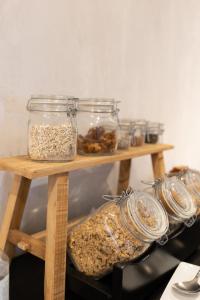 two wooden shelves with jars of food on them at Hotel Farol in Praia da Barra