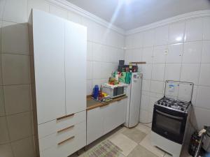 a white kitchen with a refrigerator and a microwave at Quarto em Apto Compartilhado Bem Localizado AP 204 in Uberaba