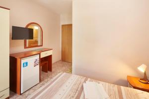 a room with a bed and a mirror and a tv at Villa Nasko Chaushev in Nesebar