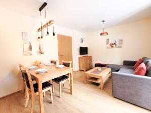 a living room with a table and a couch at Modern Mountain Apart 4 - an der Skipiste in Rauris