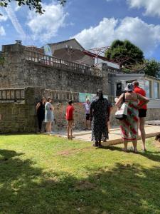 a group of people standing outside of a stone wall at Hob Fort du Pré in Saint-Bonnet-le-Froid