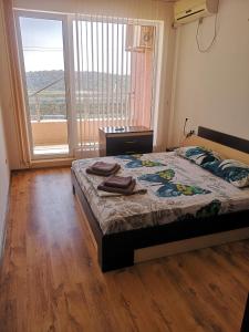 a bedroom with a bed and a large window at Seaview apartment complex Karia12 in Kavarna +46 photos