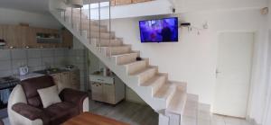 a living room with a staircase with a tv on the wall at Sara&Sami in Mostar +8 photos
