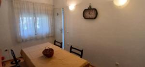 a dining room table with a clock on the wall at Sara&Sami in Mostar