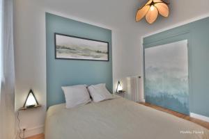 a bedroom with a large bed with two lamps at Logement 3 chambres, proche centre ville, parking gratuit in Vannes