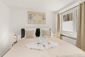 zwei weiße Schwäne auf einem Bett in der Unterkunft City Oase Bremen Zentrale Lage 300m zum Dom in Bremen