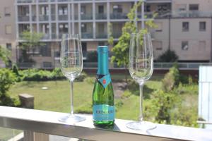 two wine glasses and a bottle of wine on a ledge at Novilda Apartments 211 in Budapest