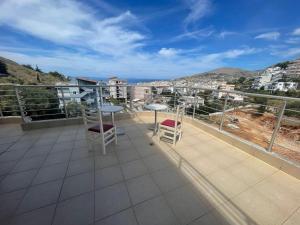 a balcony with two chairs and tables on a roof at Vanesa Rooms in Sarandë