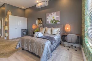 a bedroom with a bed and a desk and a chair at Trebuchet Studio Apartment in Somerset West