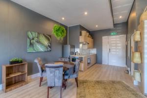 a kitchen and dining room with a table and chairs at Trebuchet Studio Apartment in Somerset West