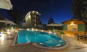 a large swimming pool at night with a building at Hotel Villa Tiziana in Marina di Massa