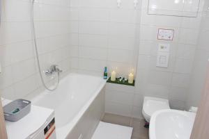 a bathroom with a tub and a toilet and a sink at Novilda Apartments 211 in Budapest