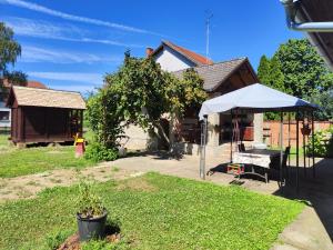 a house with a table and a white umbrella at Vila Josipa in Vukovar