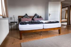 a bed sitting on top of a wooden floor at Auszeit Altenhorst, Bauernhaus in Schalksmühle