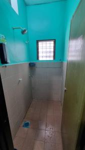 a bathroom with a shower and a blue wall at MAR Homestay Seri Iskandar in Seri Iskandar