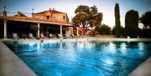 a large swimming pool in front of a house at Hotel Cigarral Santa María in Toledo