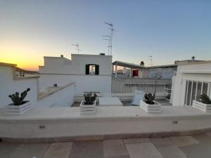 a rooftop of a building with a sunset in the background at Casamareluna in Ostuni