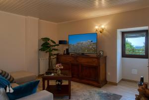 Una sala de estar con un televisor de pantalla plana y un sofá. en Casa do Fasco, en Castro Laboreiro