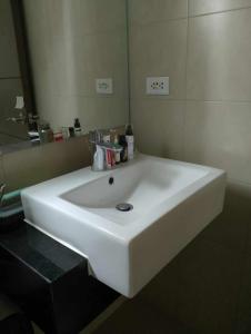a white sink in a bathroom with a mirror at Festive Walk Brand New 2 bedroom condo in Iloilo City