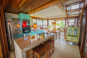 a kitchen with blue cabinets and a large island at Casa Paraíso Tropical Porto de Sauípe in Canoas