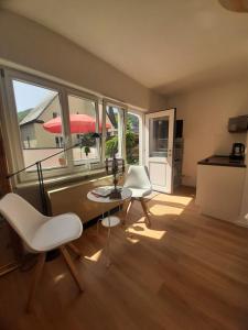 a living room with a table and chairs and windows at Mosel statt Mallorca in Mesenich