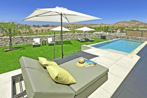 a patio with a couch and an umbrella and a pool at Salobre Las Yucas 5 in Salobre