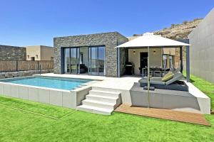 a house with a swimming pool and an umbrella at Salobre Las Yucas 5 in Salobre