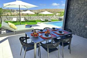a table with a bowl of fruit on a patio at Salobre Las Yucas 5 in Salobre