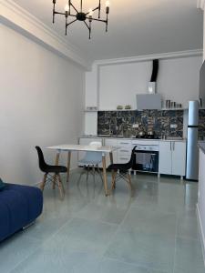 a living room with a dining room table and chairs at Nino's cozy apartment in K'obulet'i