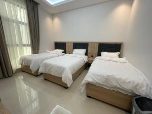 a bedroom with two beds and a window at شقة فندقية فاخرة in Al Madinah