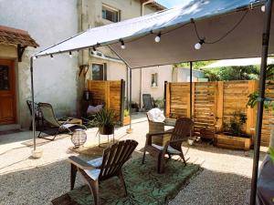 een patio met stoelen en een tafel onder een parasol bij Mas denis in Arles