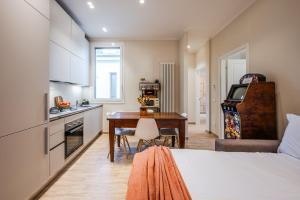 a room with a bed and a kitchen with a desk at Sui Tetti di Bologna centro, Casa Dei Colori in Bologna
